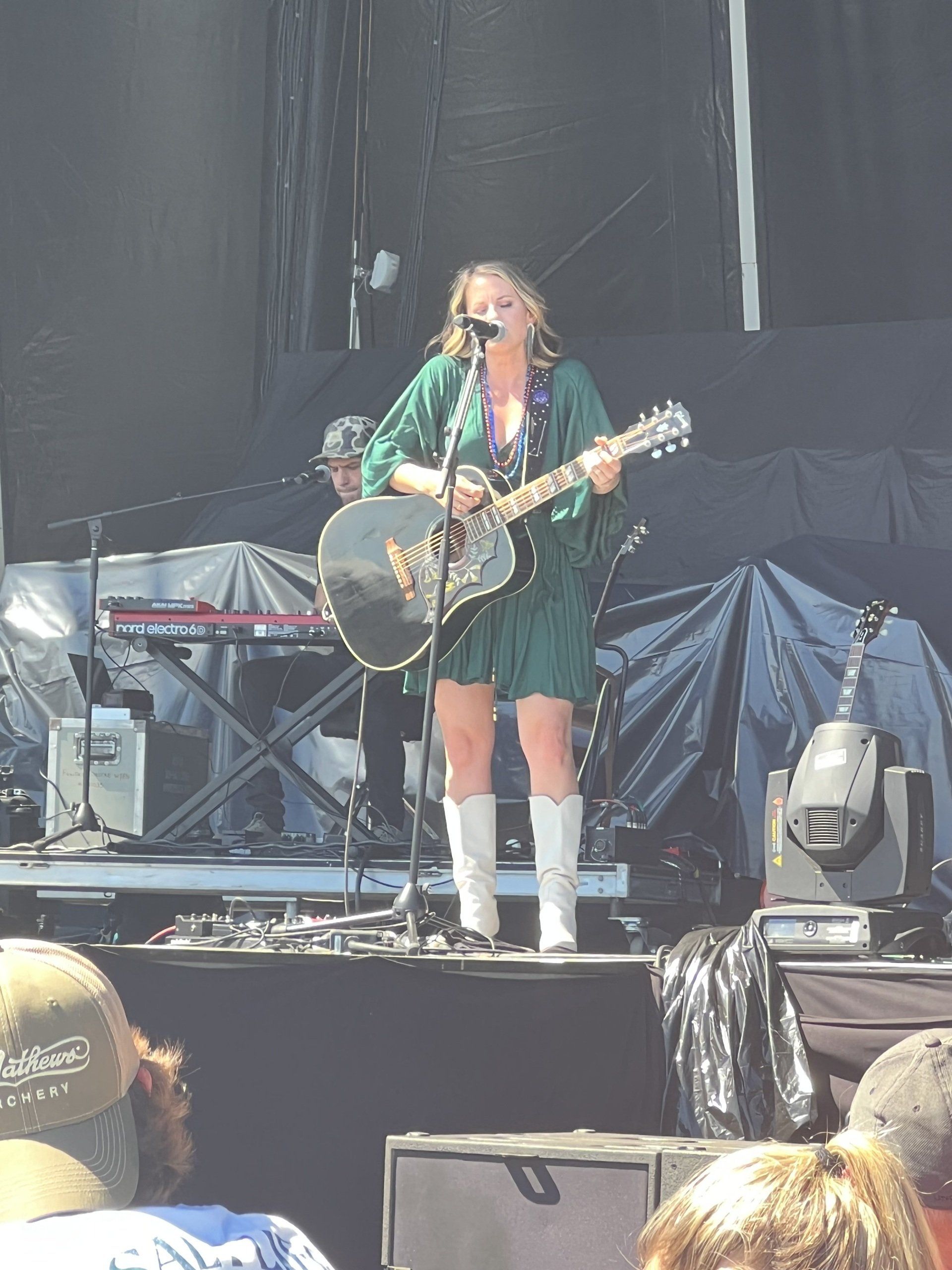 A woman singing into a microphone while playing a guitar
