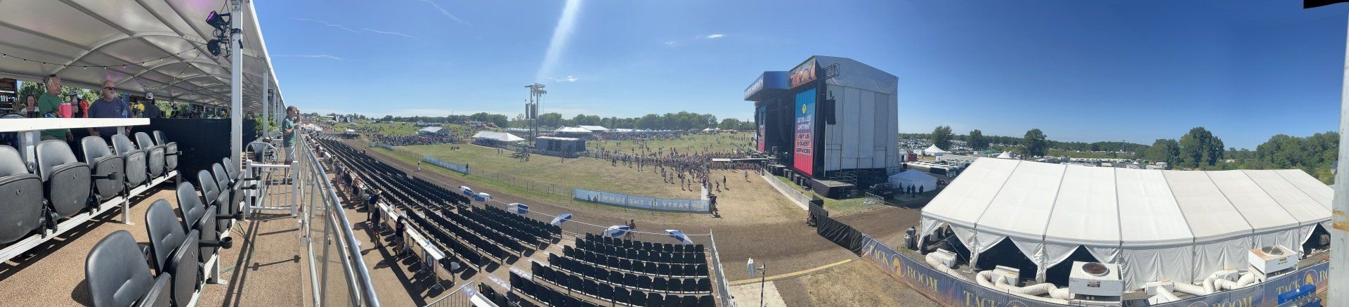 A large white tent is sitting in the middle of a field.