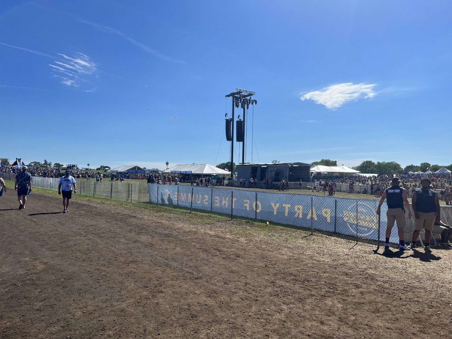 A group of people are walking through a dirt field.