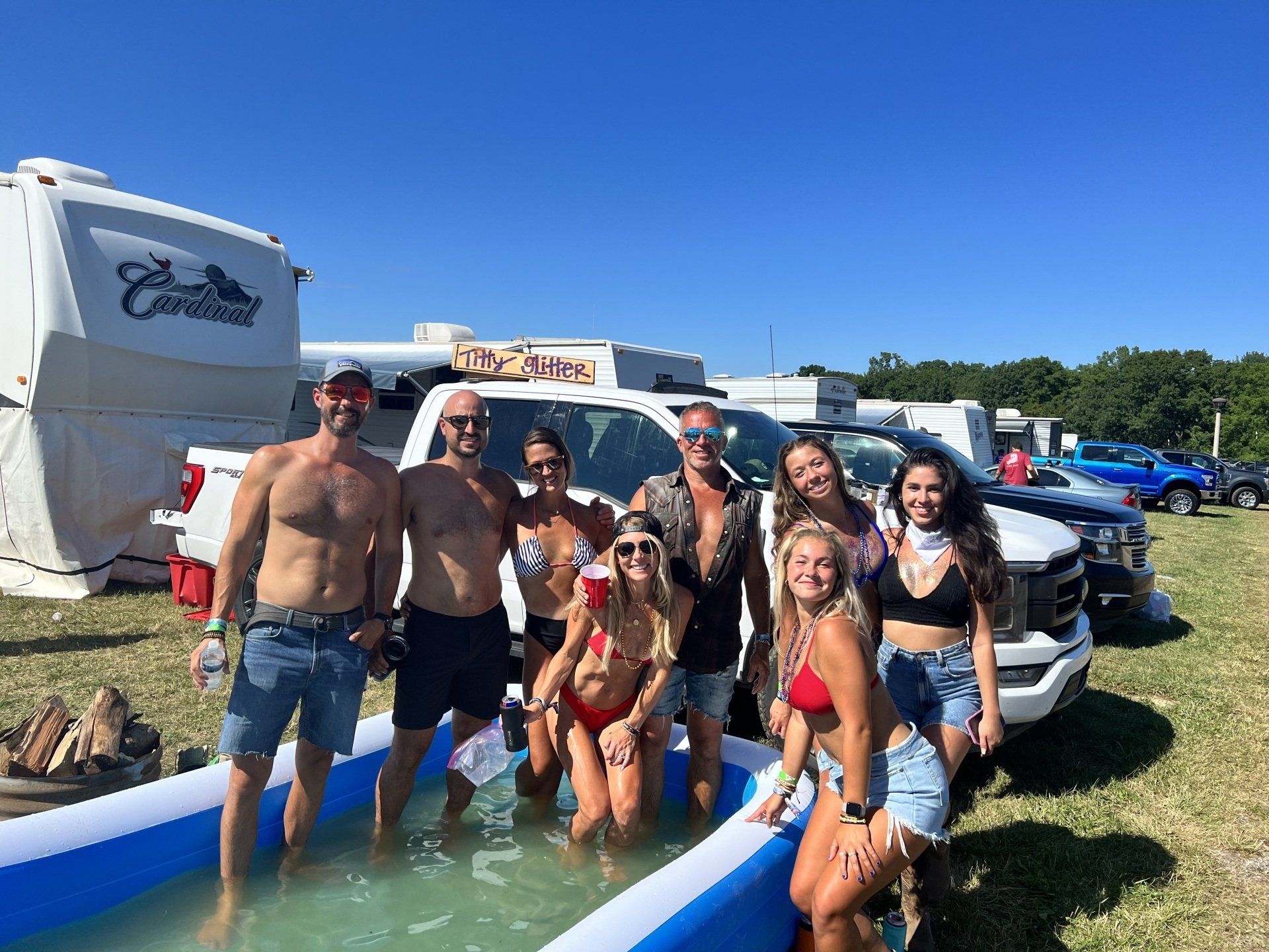 A group of people are standing in an inflatable pool.