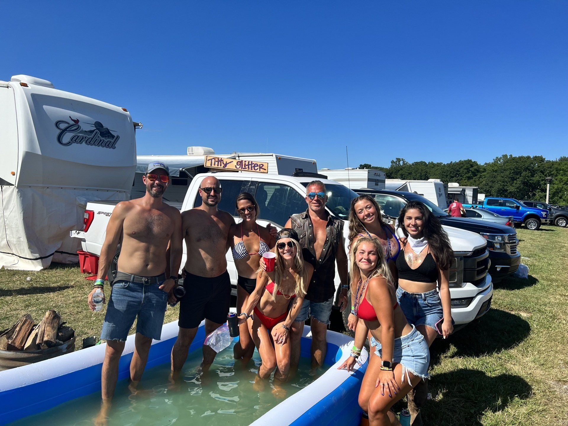A group of people are standing around an inflatable pool.