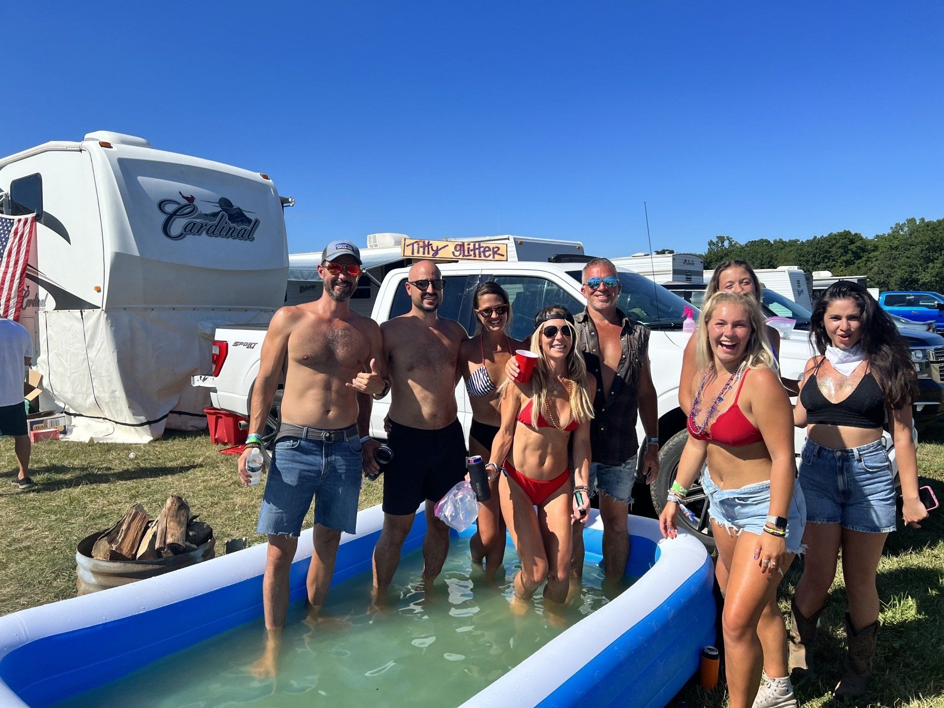 A group of people are standing around an inflatable pool.