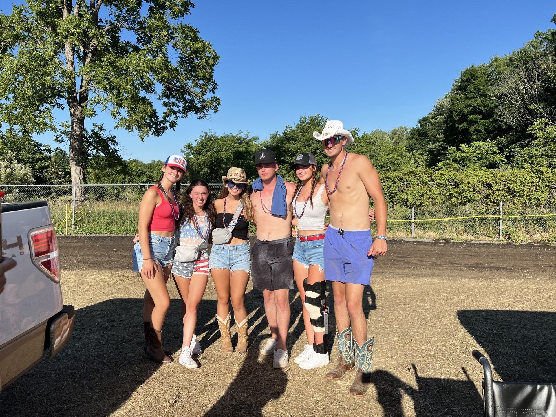 A group of people are posing for a picture in front of a truck.