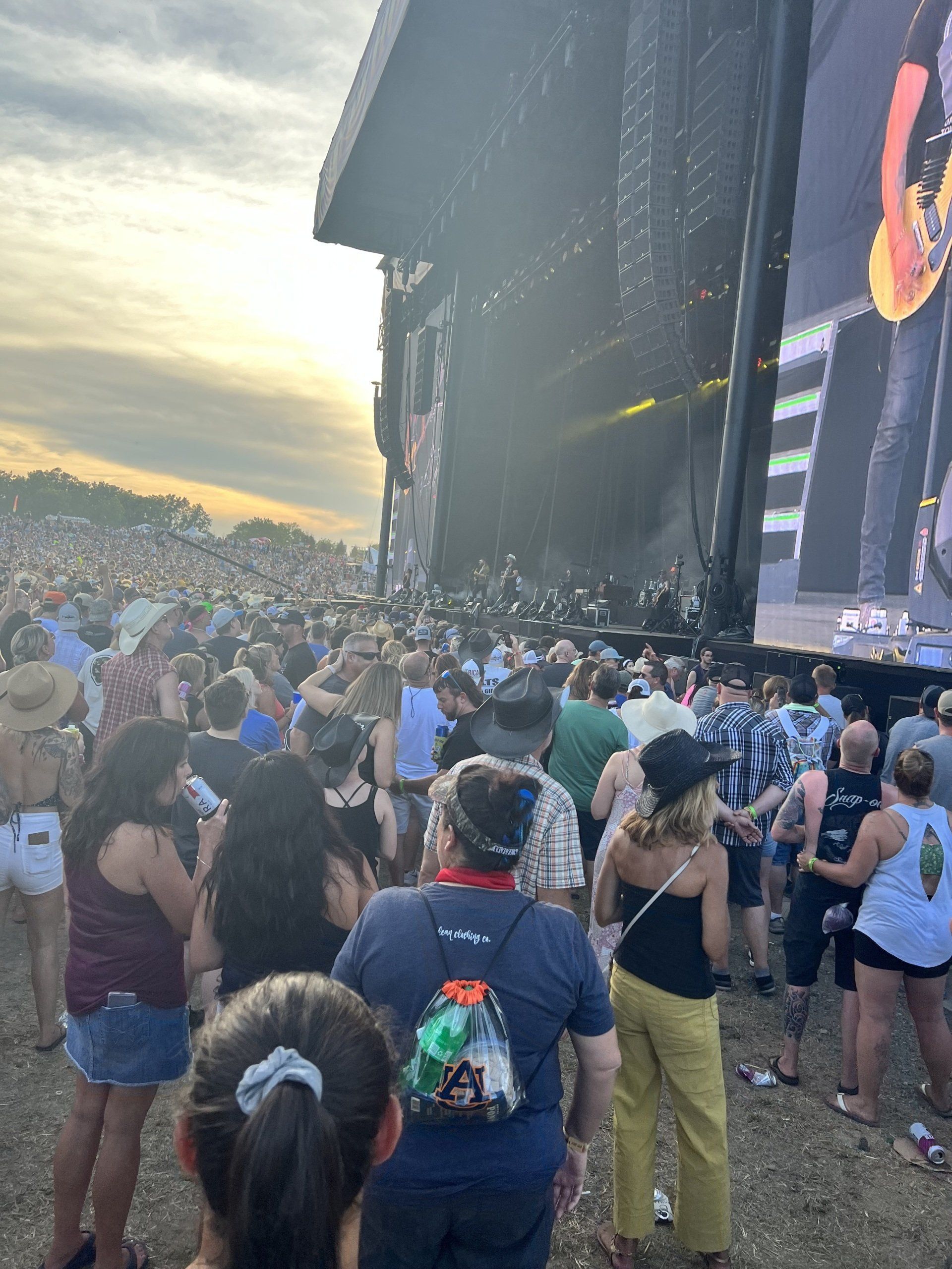 A crowd of people are standing in front of a stage at a concert.