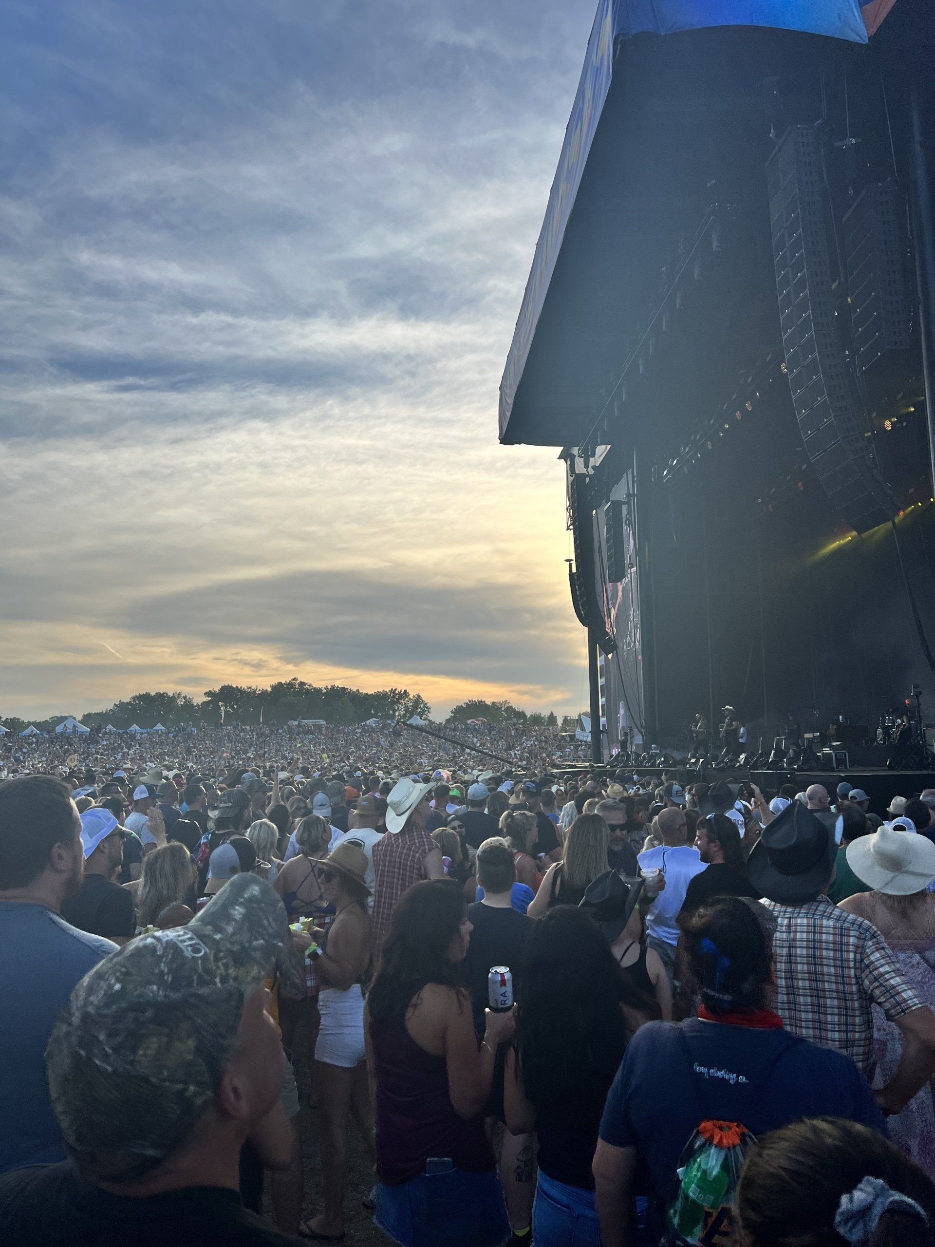 A crowd of people standing in front of a stage at a concert