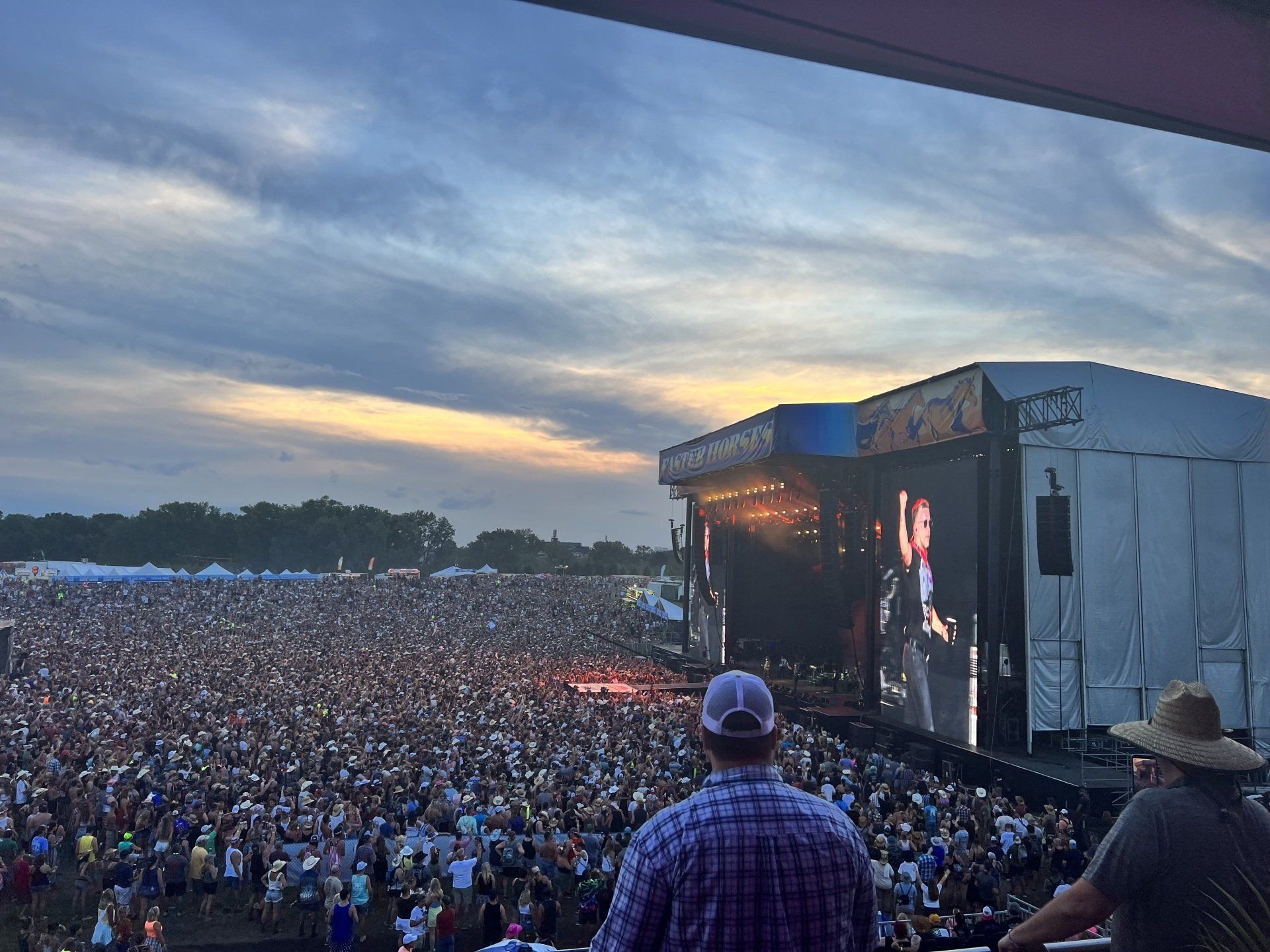 A man is standing in front of a large crowd at a concert.