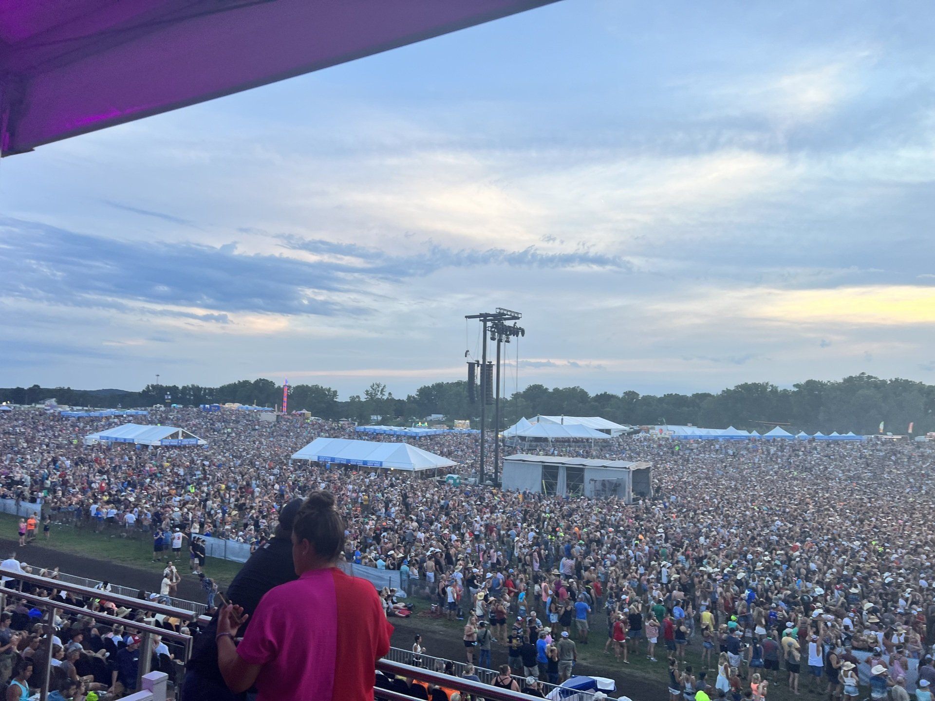 A couple is standing in front of a crowd of people at a concert.