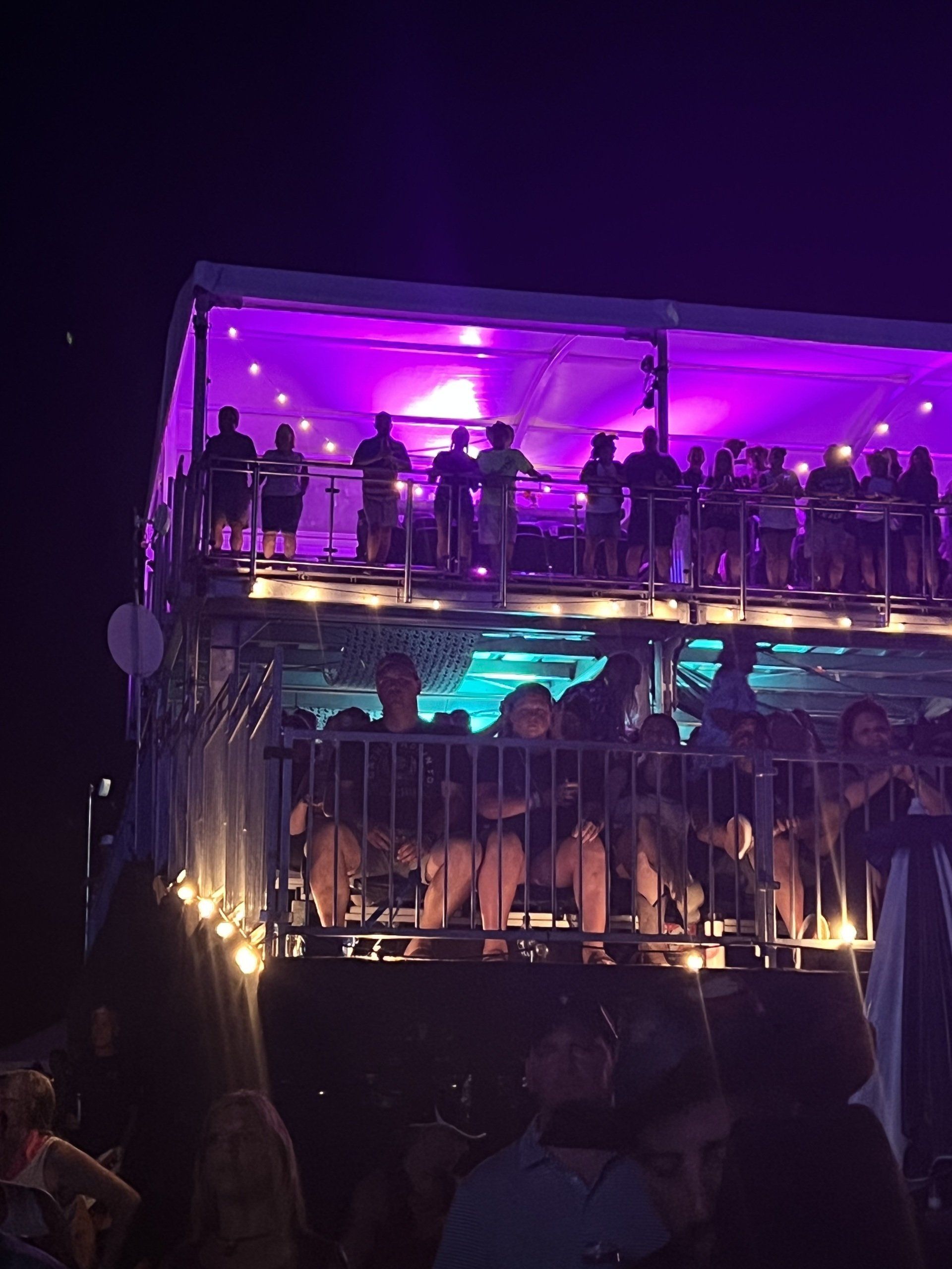 A group of people are sitting on a stage with purple lights.