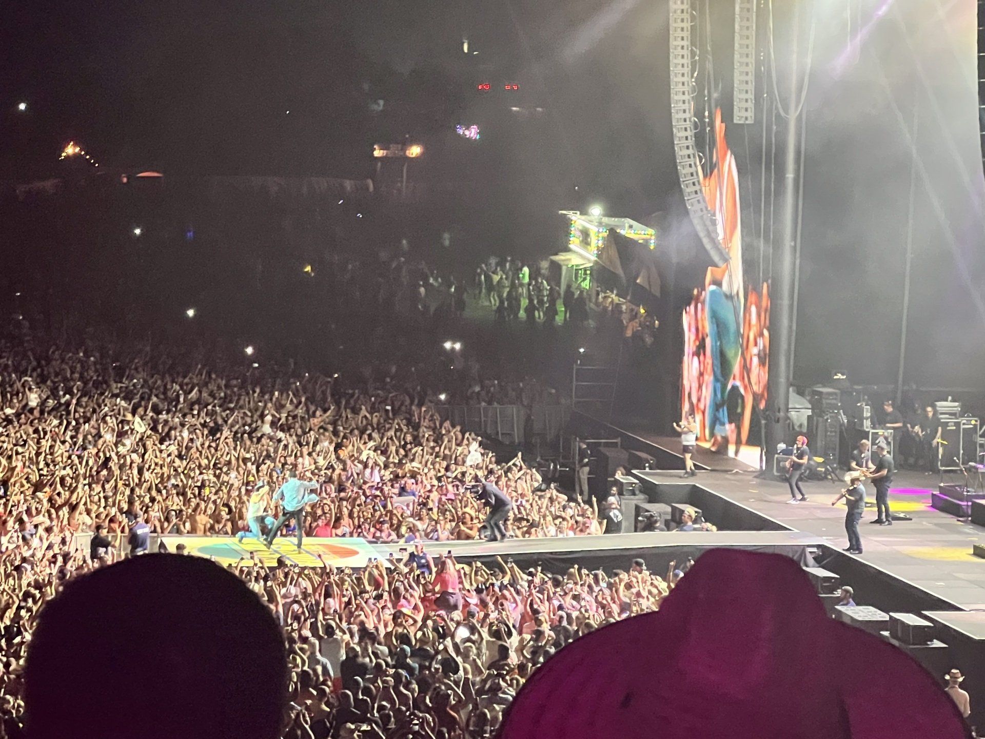 A large crowd of people are watching a concert