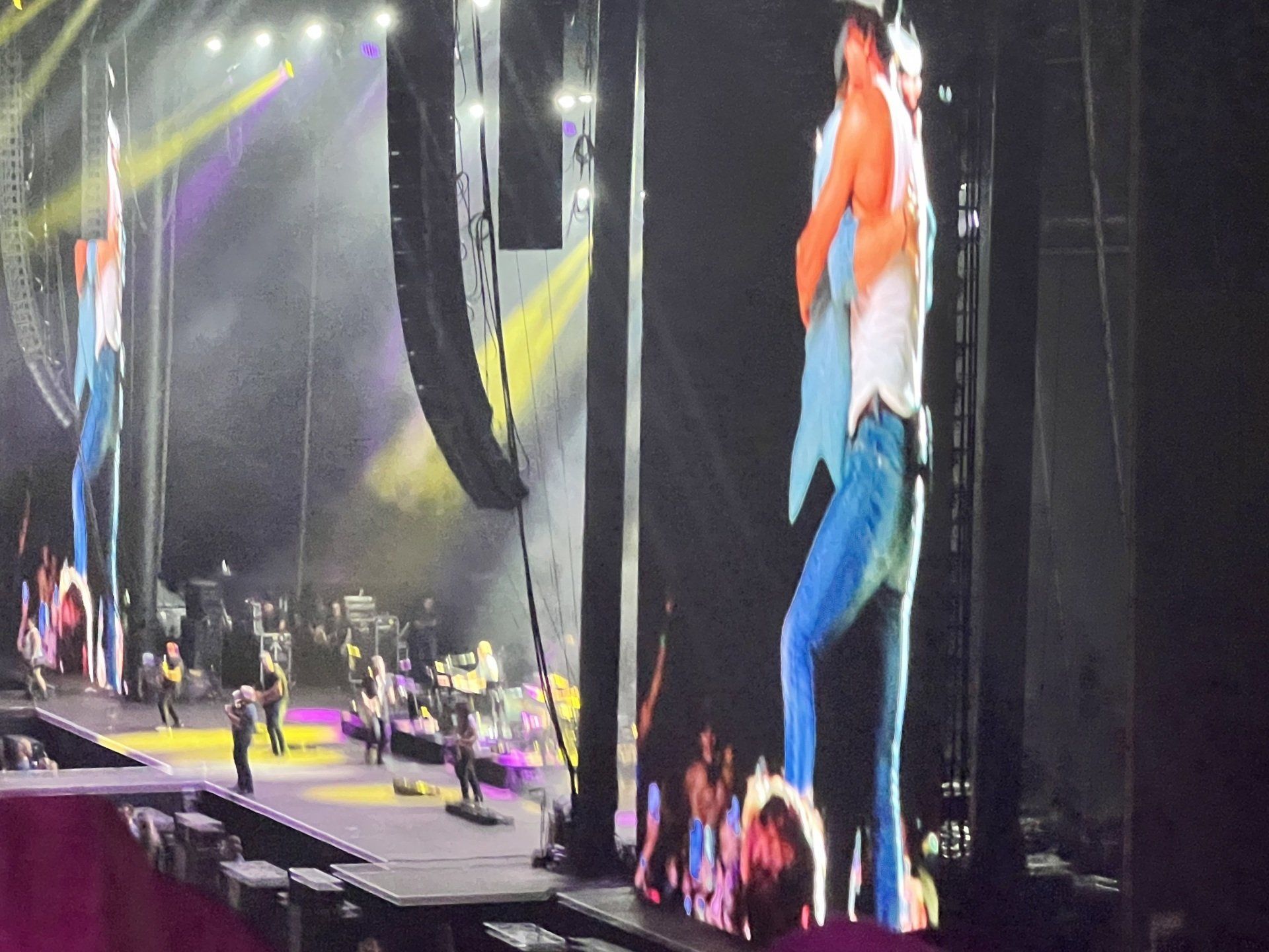 A man is hugging another man on a stage at a concert