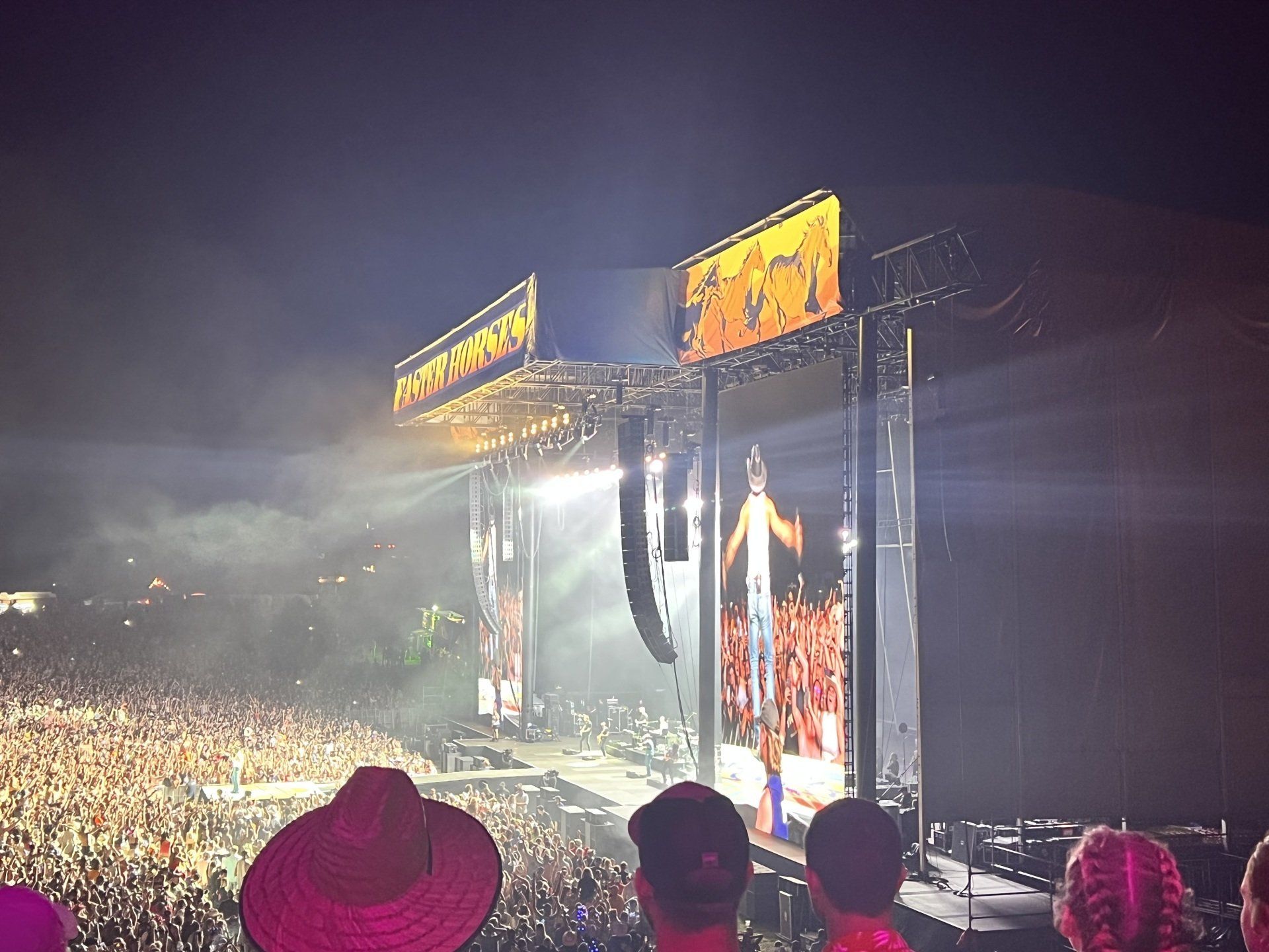 A crowd of people are watching a concert in a stadium.