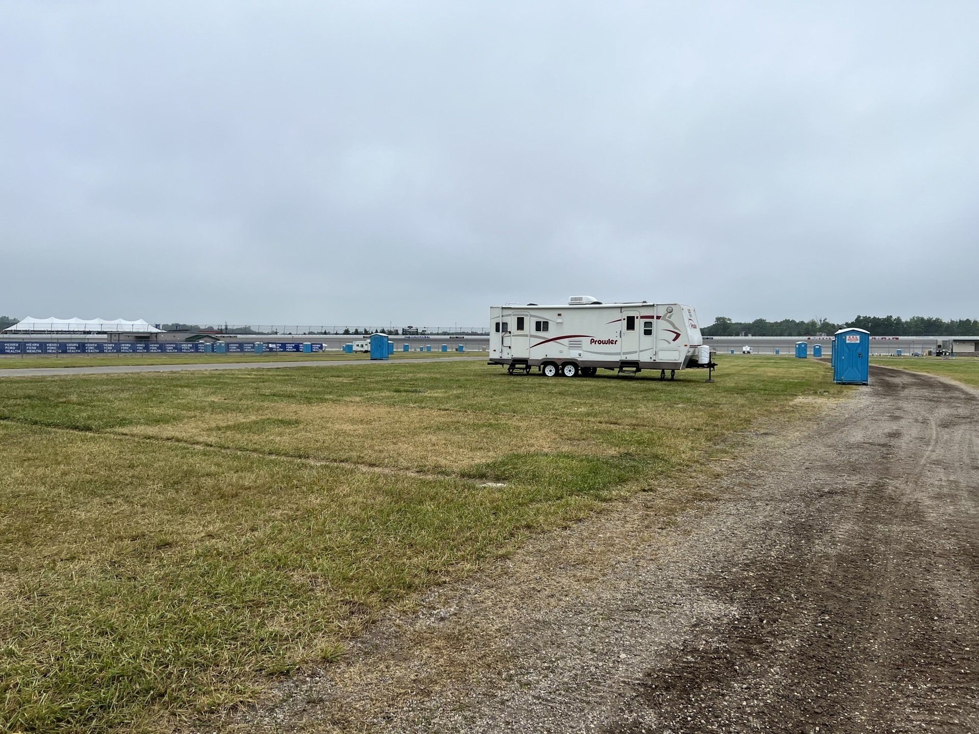 A trailer is parked in the middle of a grassy field.