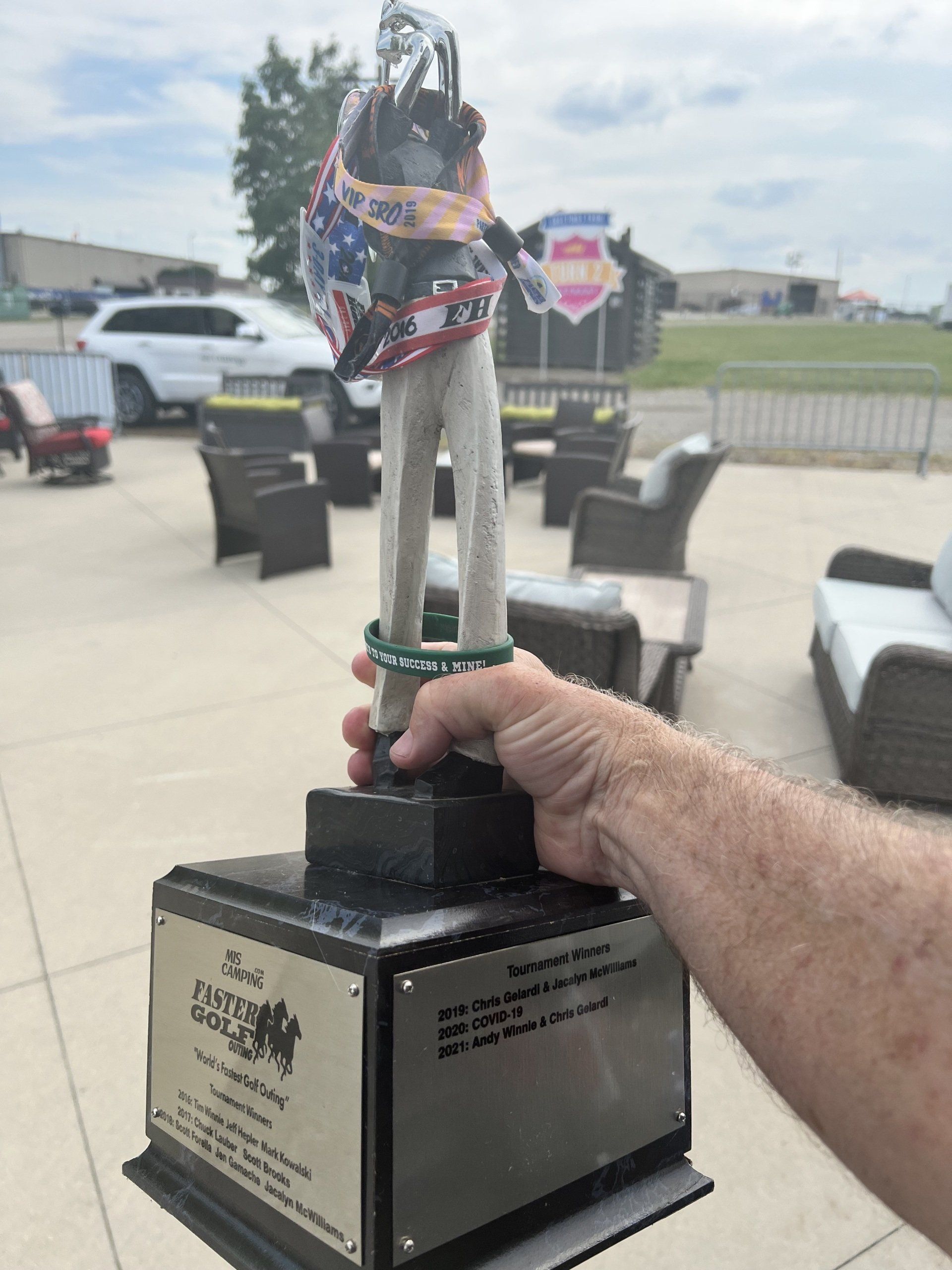 A person is holding a trophy with a helmet on it