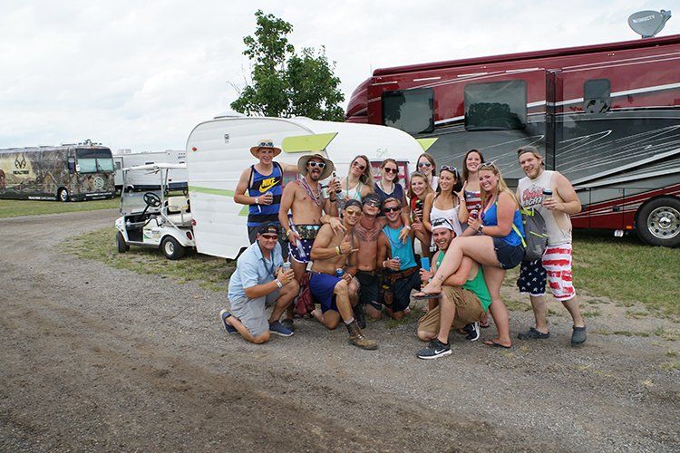 A group of people are posing for a picture in front of a rv.
