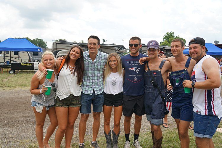 A group of people are posing for a picture together in a field.