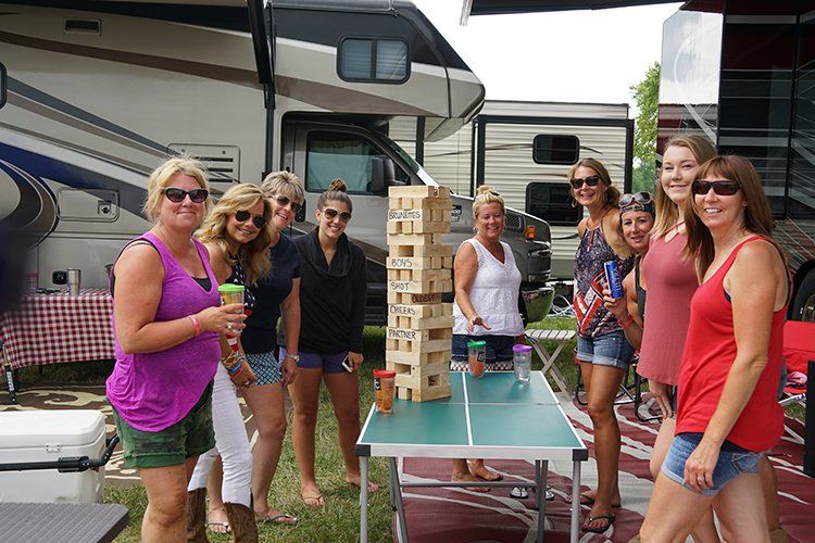 A group of women are standing around a ping pong table.