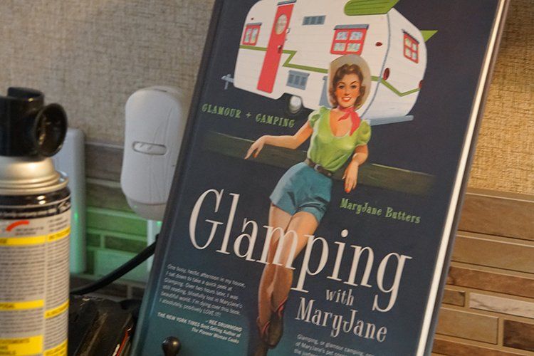 A book titled glamping with maryjane sits on a counter