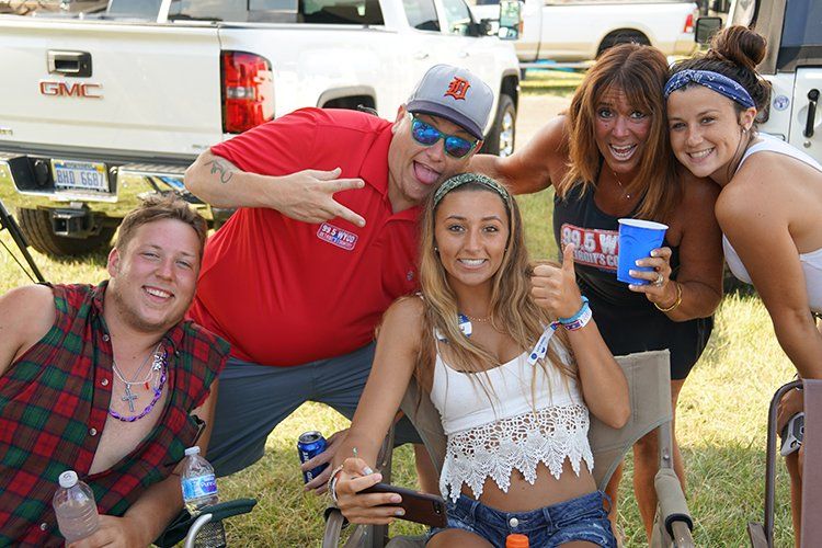 A group of people are posing for a picture in front of a gmc truck.