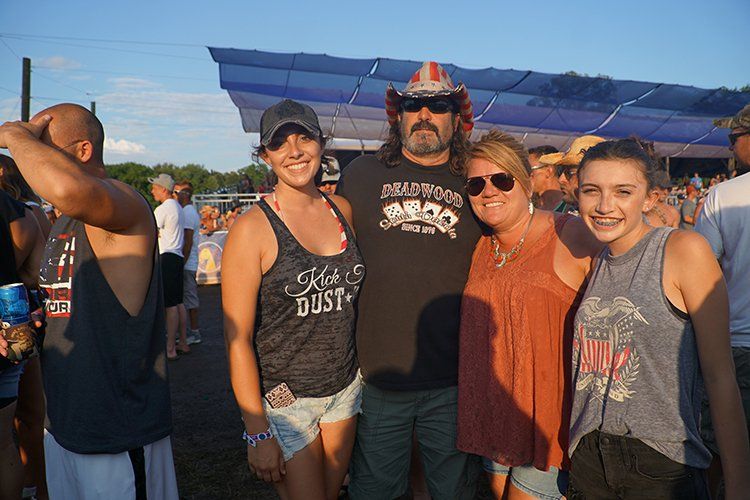 A group of people are posing for a picture at a concert.
