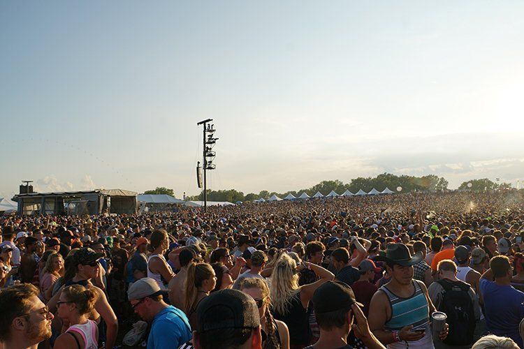 A large crowd of people are gathered at a music festival.