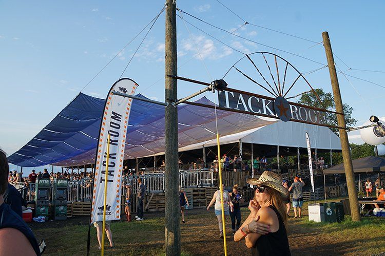 A woman standing in front of a sign that says tack room
