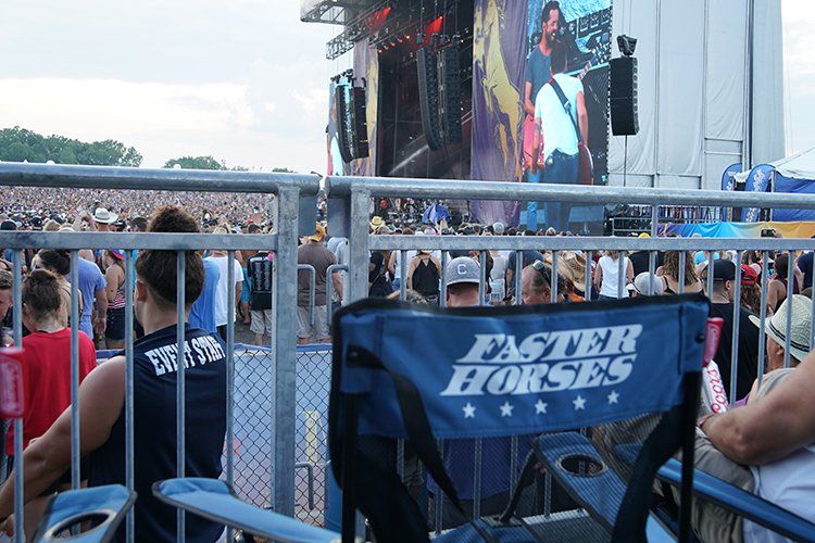 A faster horses chair is sitting in front of a crowd at a concert