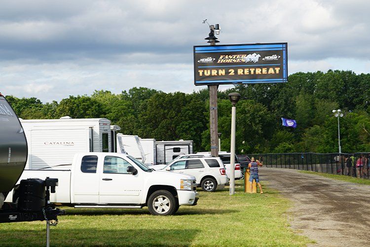 A white truck is parked in front of a sign that says turn 3 retreat