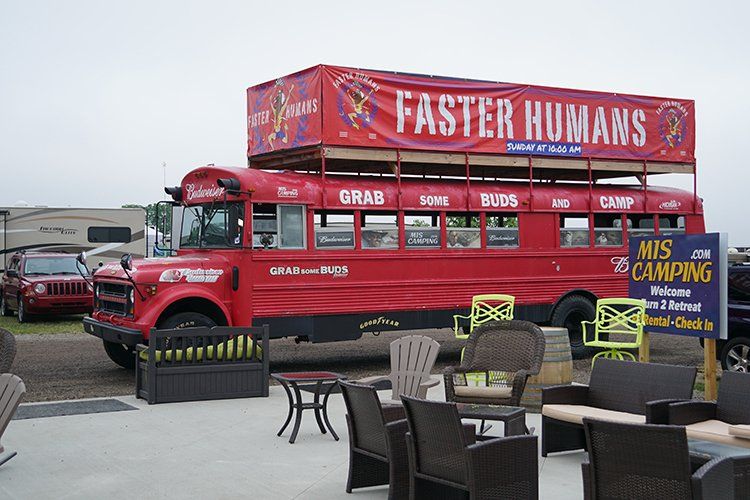 A red bus with a banner on top that says faster humans