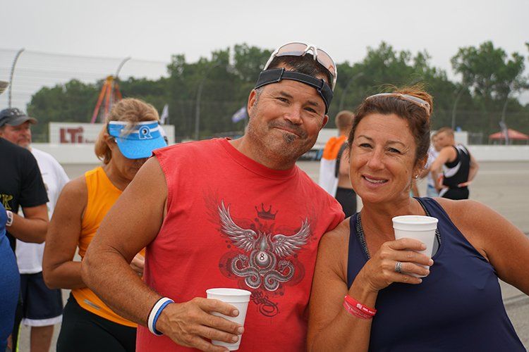 A man and a woman are posing for a picture while holding cups of coffee.