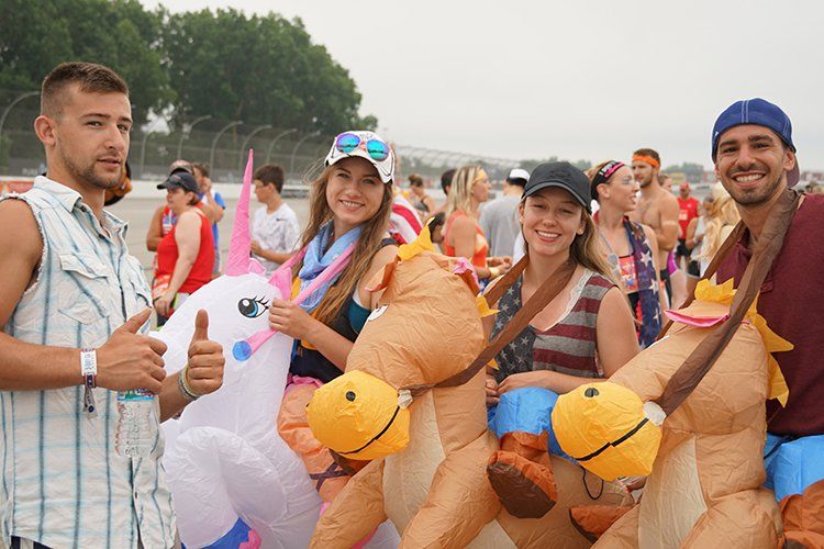 A group of people are posing for a picture with inflatable animals.