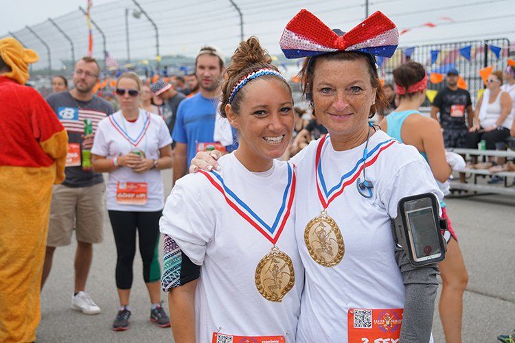 Two women posing for a picture with medals around their necks
