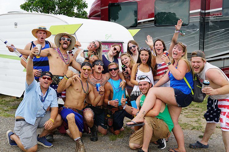 A group of people are posing for a picture in front of a trailer.