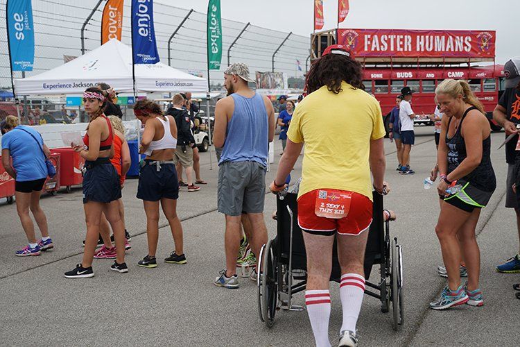 A group of people are standing in front of a sign that says faster humans