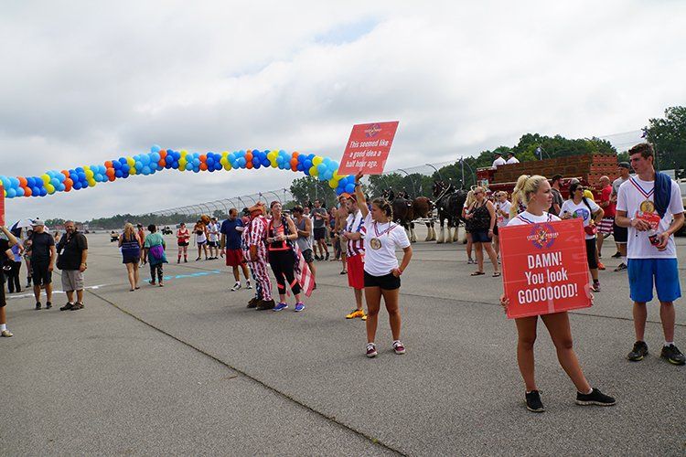 A group of people are standing in a parking lot holding signs.