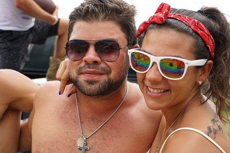 A man and a woman wearing sunglasses are posing for a picture.