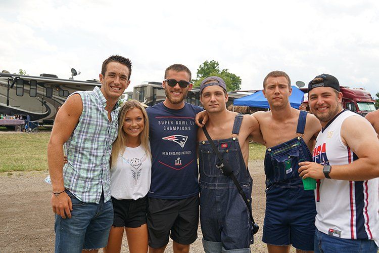 A group of people are posing for a picture in a field.