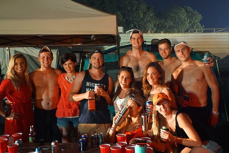 A group of people standing around a table holding drinks