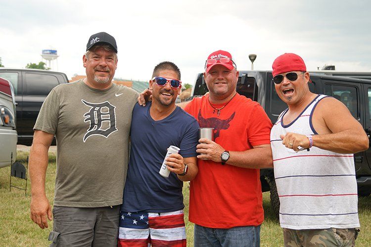 A group of men are posing for a picture in a field.