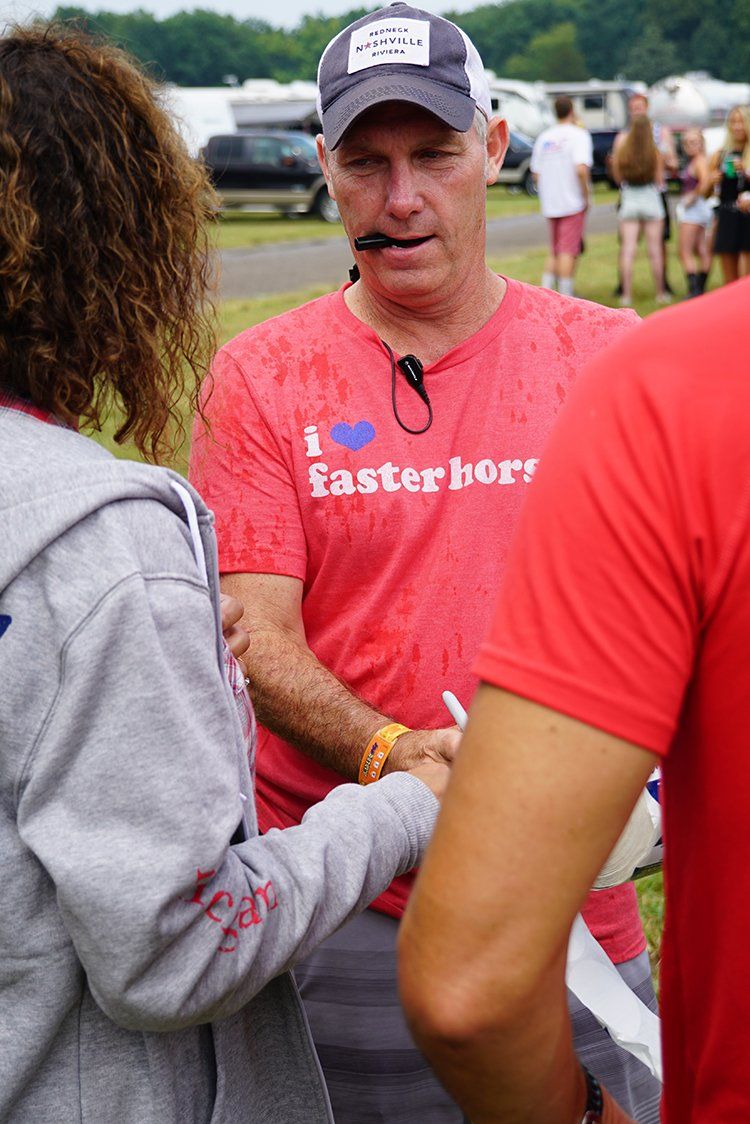 A man wearing a red shirt that says `` i love fasterbor '' is shaking hands with a woman.
