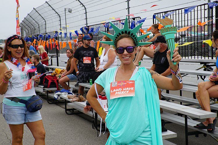 A woman dressed as the statue of liberty is standing in front of a crowd of people.