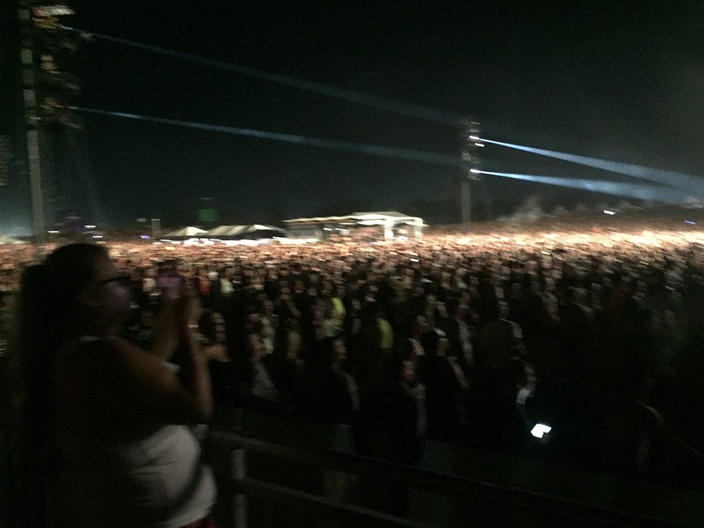 A woman is taking a picture of a crowd at a concert