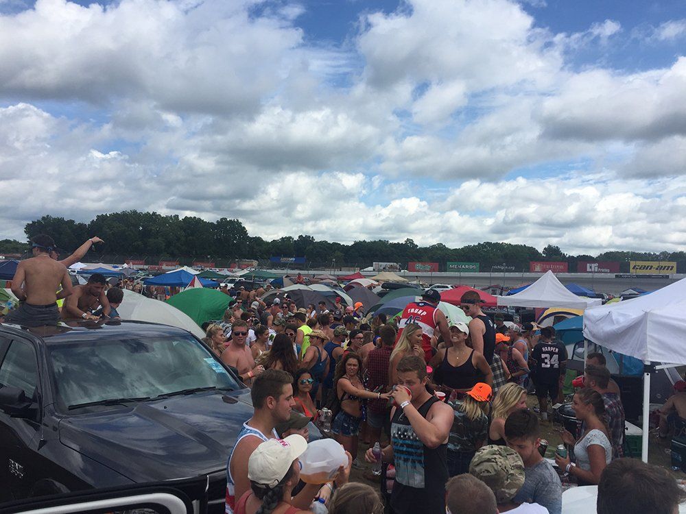 A large group of people are gathered in a parking lot.