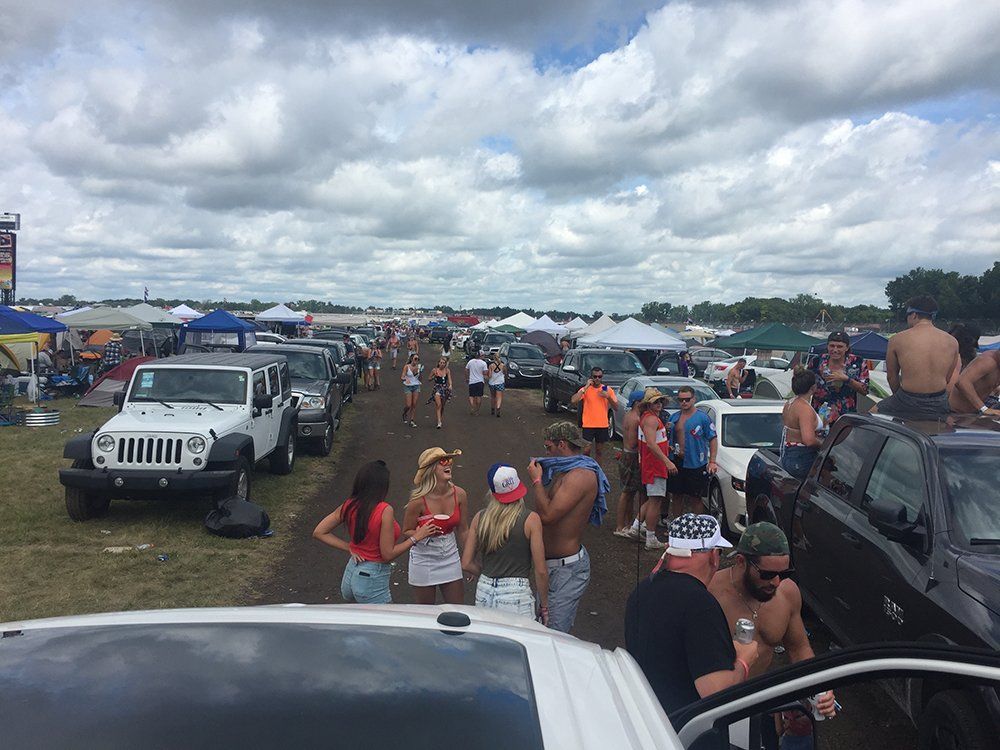 A crowd of people are gathered in a parking lot.