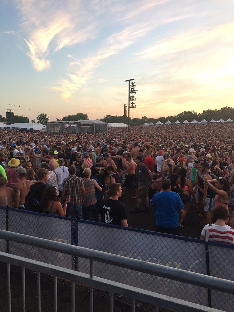 A large crowd of people are gathered at a concert.
