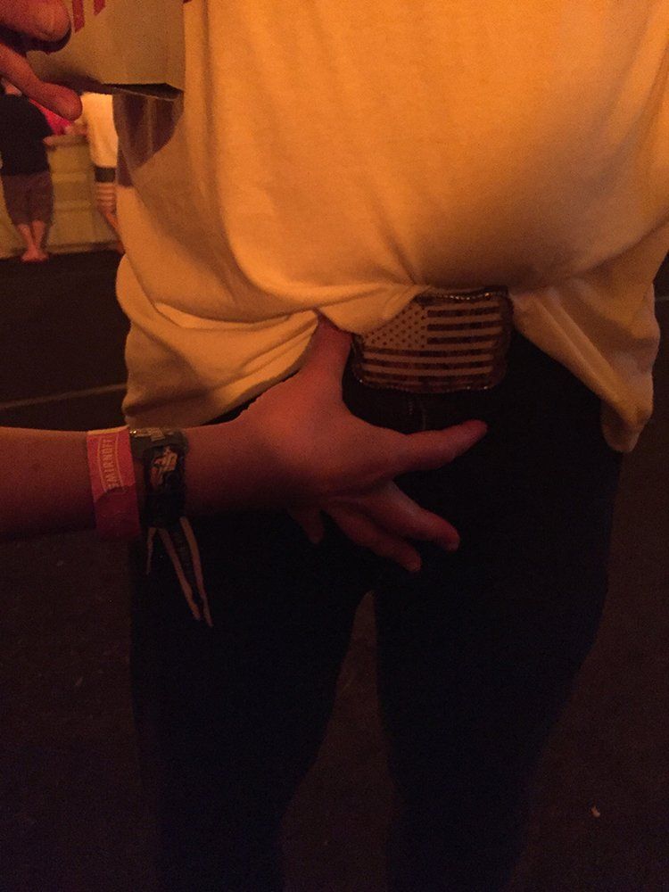 A person 's hand is on the back of another person 's waist