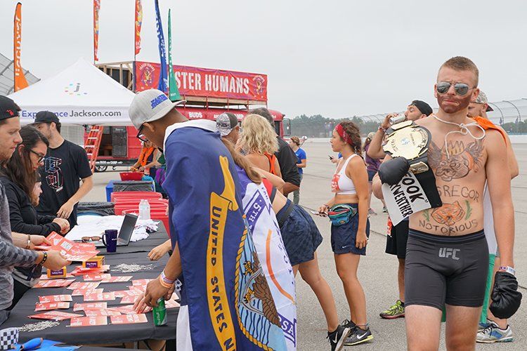 A group of people are standing around a table at a convention.