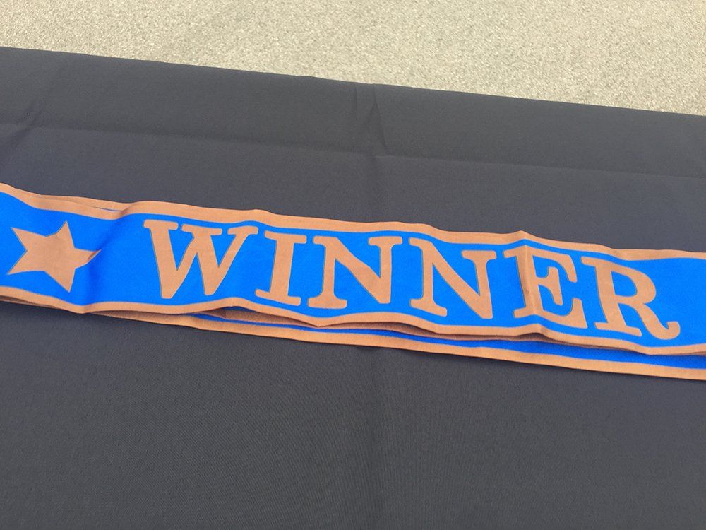 A blue and brown scarf with the word winner on it