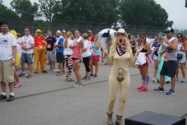A woman in a bodysuit is standing in front of a crowd of people.