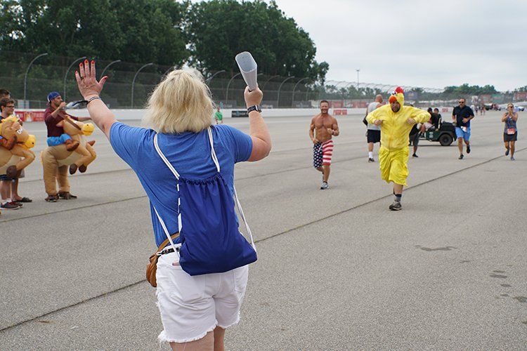 A woman in a blue shirt is standing in front of a group of people