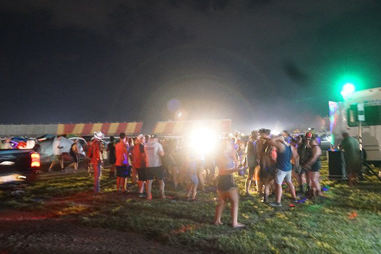 A group of people are standing in a field at night.